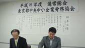 ２３年度総会で説明する鈴木専務理事と議長の椎川理事
