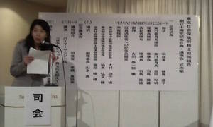 記念講演の次第と司会の茅根真由美さん