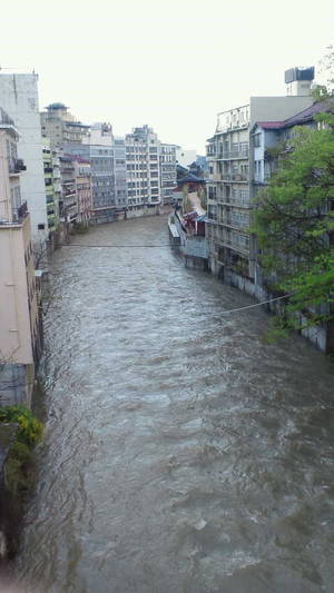 増水した飯山の旅館街を流れる川